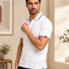 Arctic Pearl Men’s polo T-shirt with contrast collar and sleeve detailing, styled with dark trousers for a refined casual look.