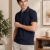 Imperial Navy Men’s polo T-shirt with contrast collar and sleeve detailing, paired with light trousers for a smart casual style.