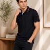 Shadow Luxe Men’s polo T-shirt with contrast collar and sleeve detailing, styled with dark trousers for a sleek casual look.
